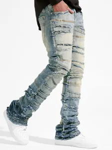 Detail view of men's blue distressed stacked jeans with ripped texture and washed finish.