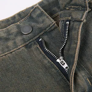 Dettaglio ravvicinato della vita di jeans vintage lavati con zip e bottone in metallo.