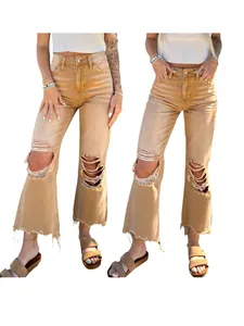 Detail of distressed tan wide-leg jeans with ripped knees and frayed hems for women