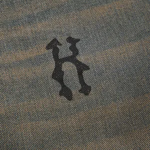 Primo piano di tessuto denim invecchiato con dettaglio stampa lettera H gotica