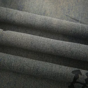 Dettaglio ravvicinato del tessuto denim vintage invecchiato con stampa grafica nera