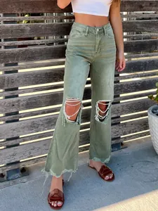 Close-up of women's high-waisted olive green ripped jeans with distressed details.