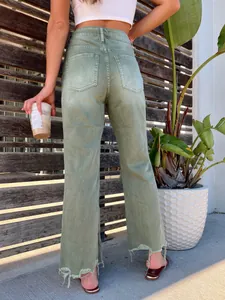 Detailed back view of high-waisted sage green wide-leg jeans with a distressed raw hem
