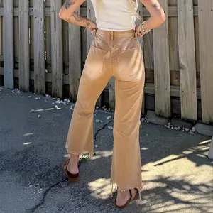 Stylish women's tan high-waisted distressed flare jeans featuring frayed raw hems back view