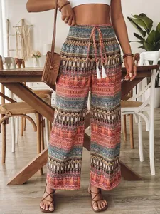 Modella che indossa pantaloni bohémien a vita alta a gamba larga con coulisse a nappe