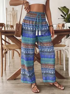 Dettaglio dei pantaloni bohémien a gamba larga con vita elastica e nappe
