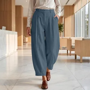Elegant blue high waist harem pants for women shown in a modern professional lobby