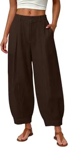 Detailed macro view of loose-fit solid brown harem pants with pleated leg details
