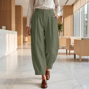 Full view of women's loose olive green cropped harem pants in a modern office setting.
