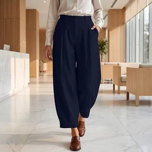 Full-length view of navy blue high-waisted harem pants in a modern office setting