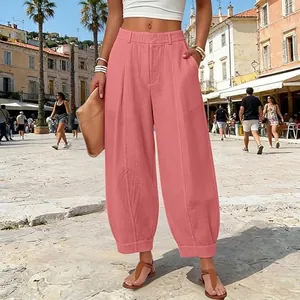 Detailed view of pink high-waisted harem pants captured in a summer street style setting