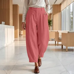 Close-up of coral high-waisted cropped harem pants featuring a pleated front design