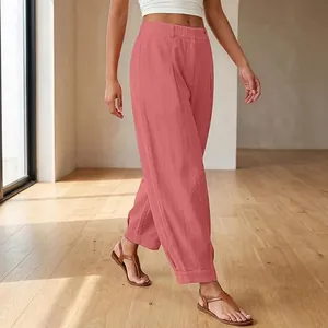 Casual women's loose pink cropped harem pants shown in a minimalist indoor setting.