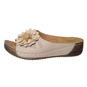 Gros plan de sandale compensée beige avec grand détail de fleur décorative 3D