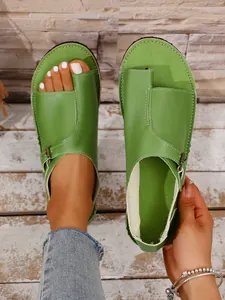 Macro detail of casual green leather toe-loop sandals with adjustable flat buckle strap