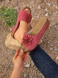 Vue détaillée de sandales compensées roses avec fleur décorative et motifs laser