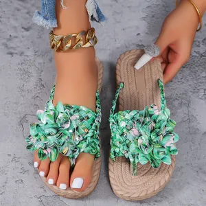 Gedetailleerde close-up van damesstrandsandalen met levendige groene tropische bloemen