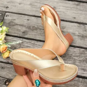 Detailed macro shot of golden chunky heel thong sandals with elegant cross-over straps
