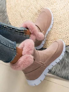 Vue détaillée de la bordure en fausse fourrure rose sur ces bottes d'hiver en daim.