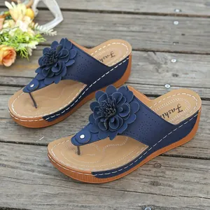 Elegant navy blue wedge flip-flops featuring a large 3D flower ornament on the thong strap