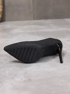 Detailed view of the anti-slip sole on a black sequined pointed toe stiletto pump.