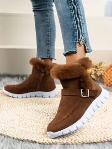 Gros plan de bottes de neige marron pour femmes avec bordure en fourrure et boucle en métal