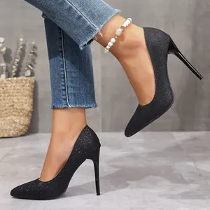 Close-up detail of elegant black glitter pointed-toe stiletto heels worn by a fashion model