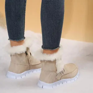 Gros plan de bottes de neige beiges pour femmes avec garniture en fourrure sur la neige