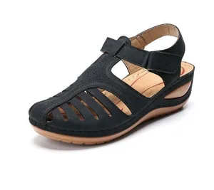 Detailed side view of black vintage women's wedge sandal with stylish cut-out hollow pattern