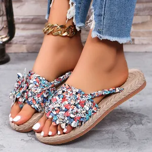 Close-up van dames strandsandalen met kleurrijke gevlochten bloemen en dikke zolen.