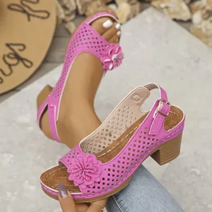 Primo piano di sandali rosa traforati con fiore decorativo e tacco largo stabile