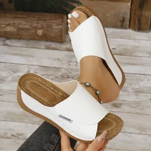 Detailansicht der weißen Peep-Toe-Keilsandaletten mit stylischer brauner Plateausohle