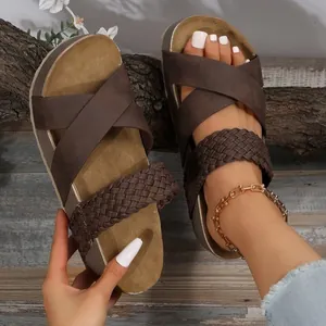 Close-up van bruine dames platform sandalen met gekruiste gevlochten bandjes