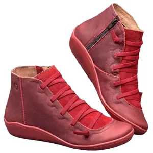 Red vintage style women's ankle boots with side zipper and laces on white background.