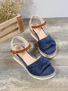 Sandali con zeppa in camoscio blu navy con elegante fiocco e suola in corda rustica.
