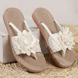 Detail van de elegante witte bloemdecoratie en geweven textuur op beige strand sandalen