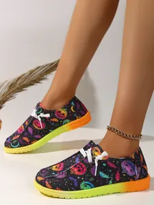 Halloween-themed canvas shoes with pumpkin and ghost prints on flat gradient soles.
