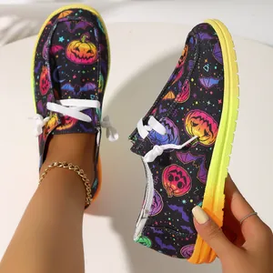 Detail view of women's Halloween pumpkin print canvas loafers with a vibrant gradient rubber sole