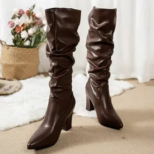 Slouchy brown leather knee-high boots with pointed toe and chunky heel detail