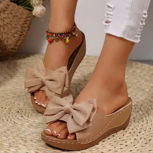 Elegante khakifarbene Keilsandalen mit großer Schleife für den sommerlichen Freizeitlook