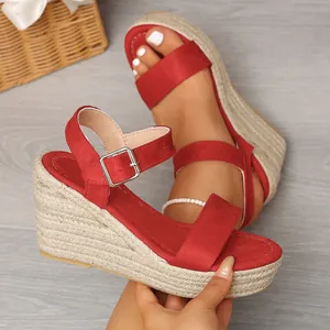 Detailed view of red suede espadrille wedge sandals featuring a rope-wrapped platform