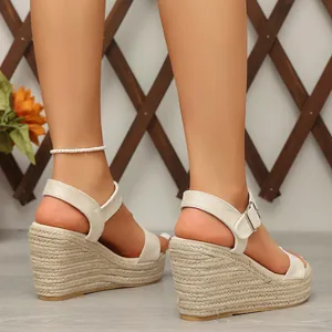 Close-up detail of women's beige high heel wedge sandals with braided hemp rope platform