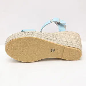 Detailed view of light blue espadrille wedge sandal with textured rubber outsole