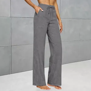 Macro detail view of high-waisted grey linen-texture trousers with side pockets and drawstring.
