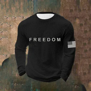 Close-up detail of a men's black waffle knit sweatshirt with Freedom chest print.