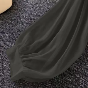 Macro view showing the soft texture and gathered cuff of dark grey chiffon sleeve