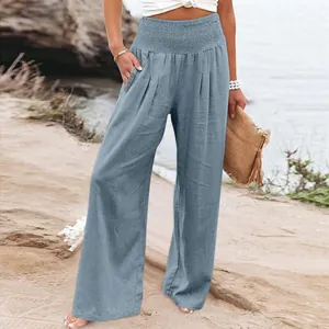 A close-up shot of blue wide-leg linen pants with a high elastic waist and button details