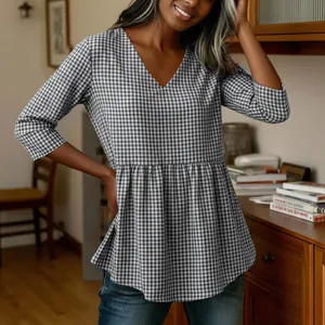 Close-up of women's V-neck gingham blouse with a stylish peplum hem for summer.