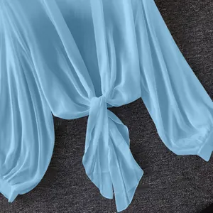Detailed macro shot of light blue breathable chiffon sun protection shirt with front-tie