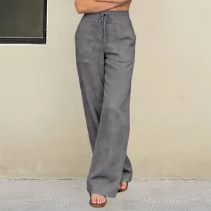 Detailed view of gray high-waisted wide-leg trousers featuring drawstring and large pockets.